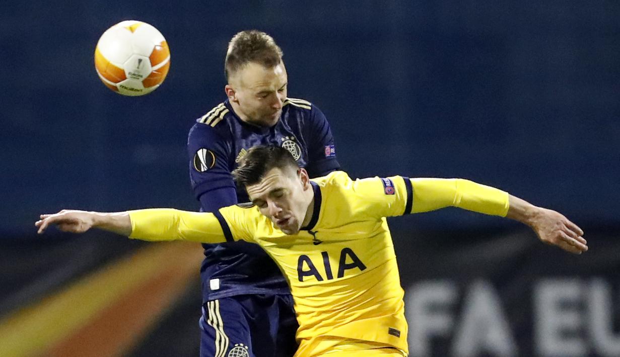 Gelandang Tottenham Hotspur, Harry Winks (kanan) berduel udara dengan bek Dinamo Zagreb, Sadegh Moharrami dalam laga leg kedua babak 16 besar Liga Europa 2020/2021 di Maksimir Stadium, Zagreb, Kamis (18/3/2021). Tottenham kalah 0-3 dari Dinamo Zagreb. (AP/Darko Bandic)