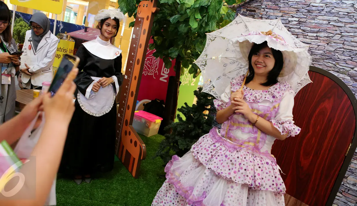 Seorang pengunjung berpose mengenakan baju ala Swiss di Kota Kasablanka, Jakarta (12/11). Kegiatan yang digelar 12-13 November ini menyajikan beragam kegiatan edukasi mengenai gizi dengan menyusuri Museum Mini Nestle. (Liputan6.com/Fery Pradolo)