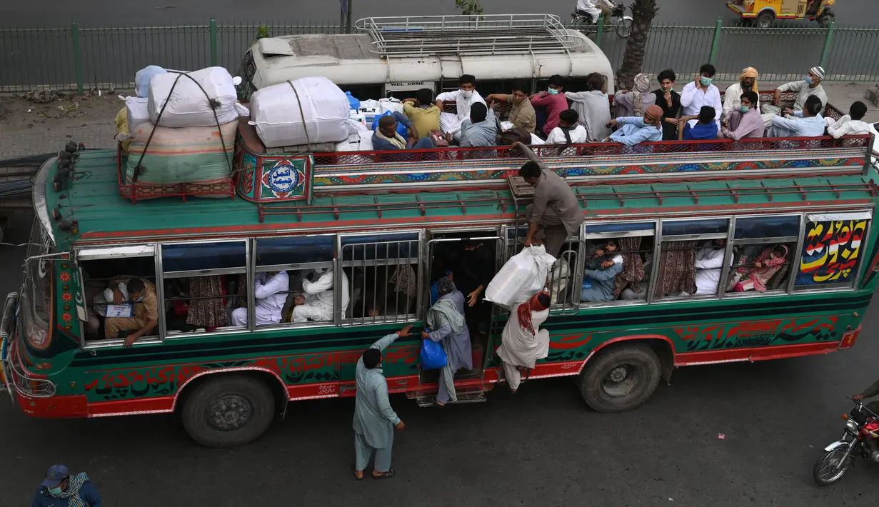 Warga menaiki bus saat mereka melakukan perjalanan ke kampung halaman mereka menjelang perayaan Idul Fitri di Lahore (7/5/2021). Lebaran Idul Fitri jatuh pada 13 Mei 2021. (AFP Photo/Arif Ali)