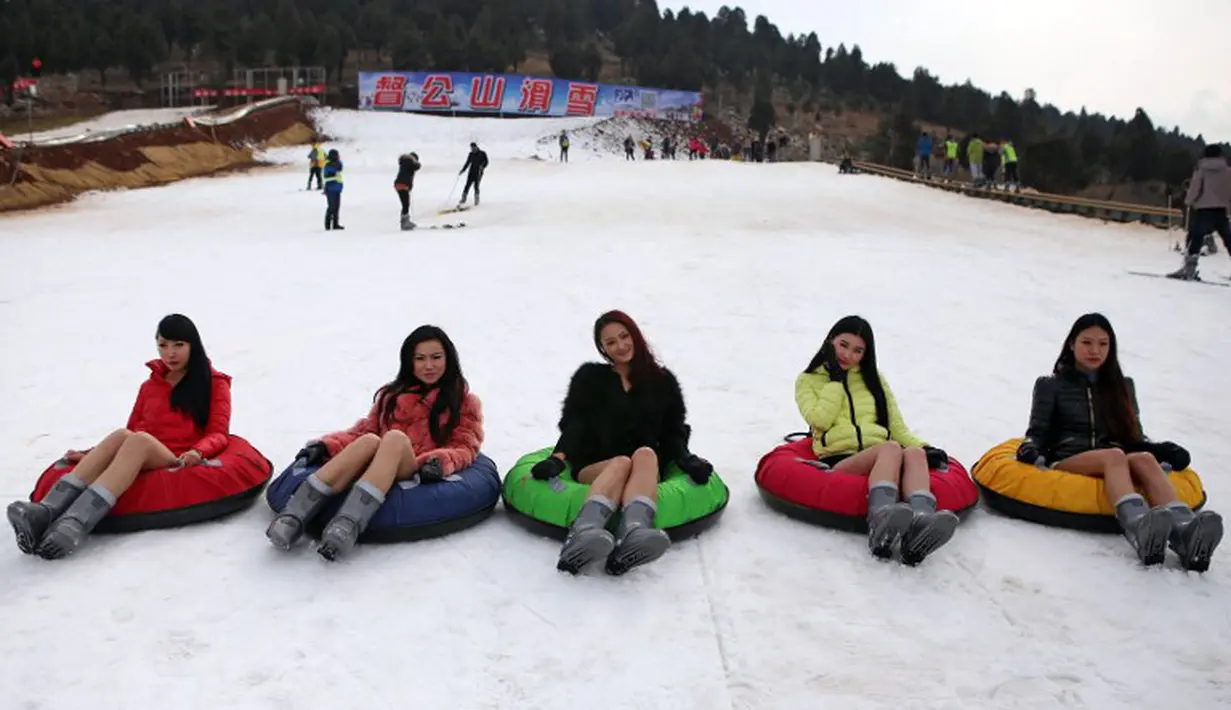 Lima wanita bermain snow tubing tanpa mengenakan celana saat ikut berpatisipasi dalam No Pants Subway Ride di Dugongshan Ski Resort, Cina. Foto diambil Selasa (13/01/2015). (CHINA OUT AFP PHOTO)