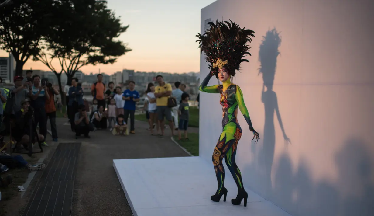 Model berpose selama sesi pemotretan untuk Daegu International Bodypainting Festival 2017 di Daegu, Korea Selatan, (26/8). Dengan tubuh yang sudah dipenuhi pola dan gambar berwarna-warni, para model berjalan di hadapan ratusan pengunjung. (Ed JONES / AFP)