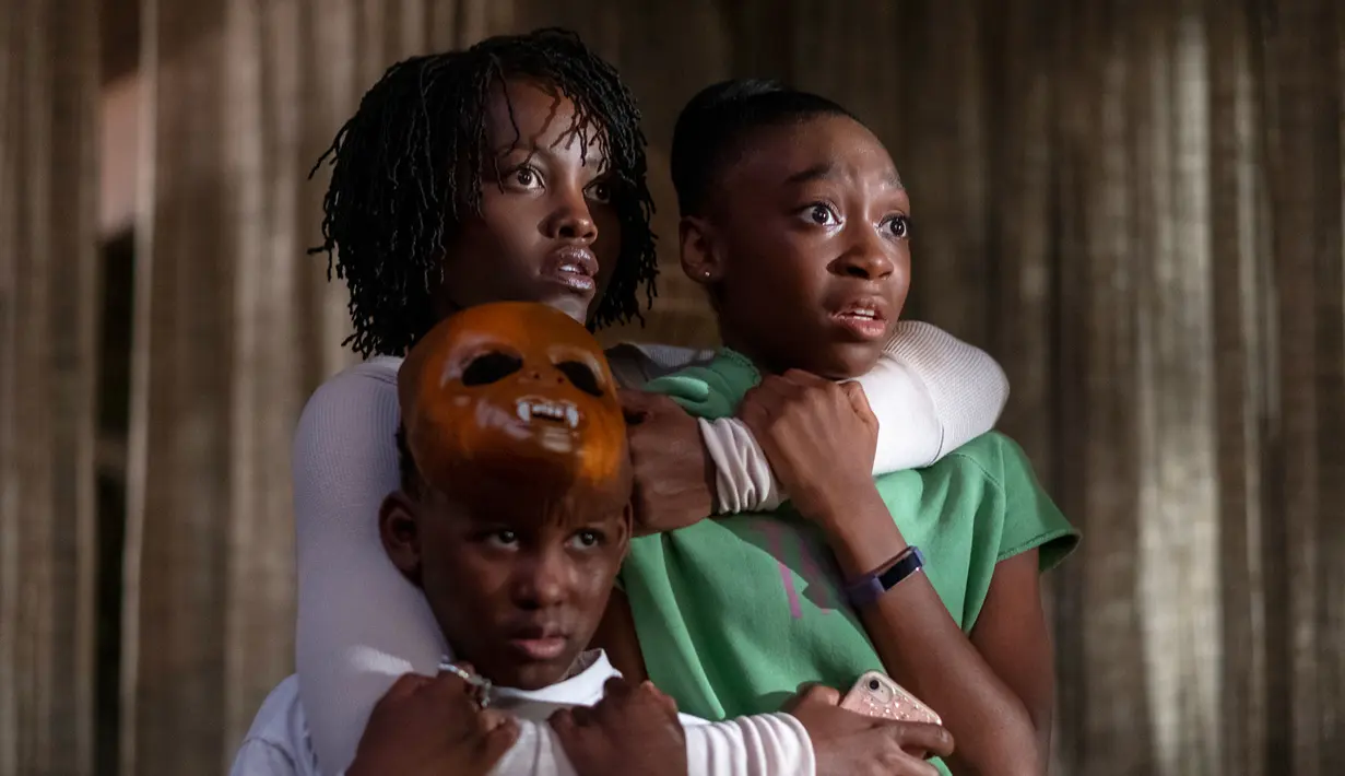 Evan Alex, Lupita Nyong'o dan Shahadi Wright Joseph dalam sebuah adegan film 'Us'. Film ini bercerita tentang liburan sebuah keluarga ke tempat terasing yang ternyata menjadi teror mencekam. (Claudette Barius/Universal Pictures via AP)