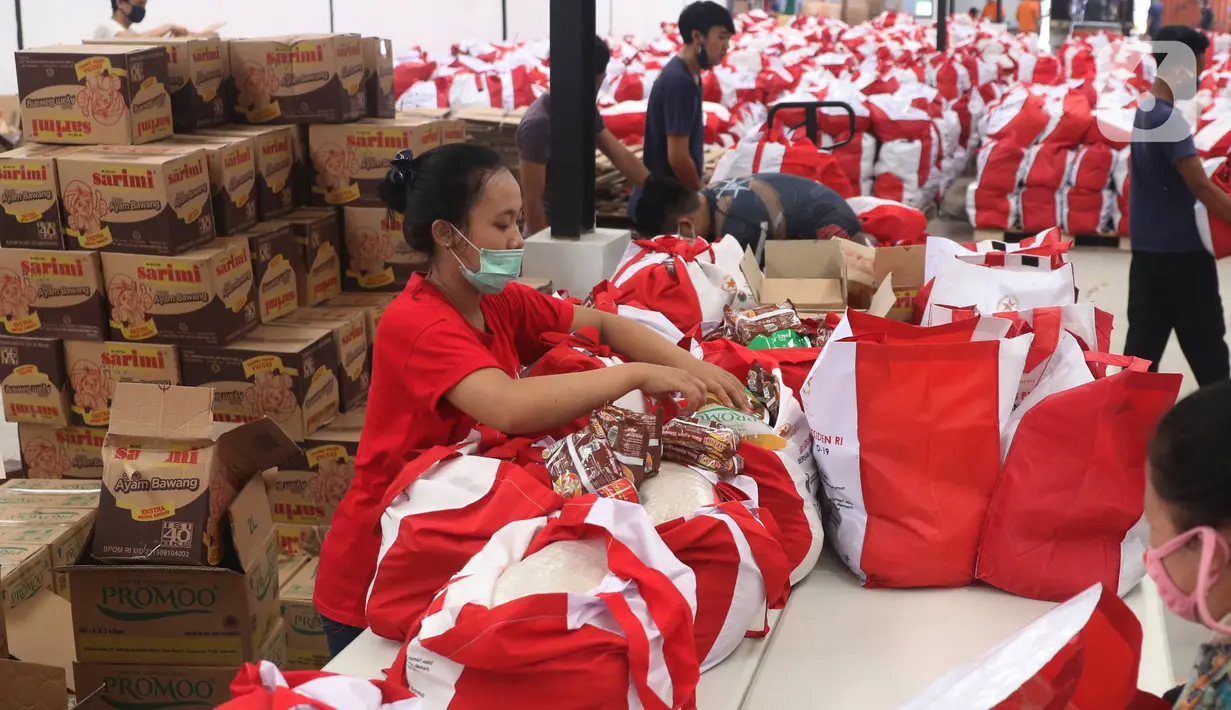 Pekerja sedang mengemas bantuan paket sembako dari Presiden Joko Widodo di Tangerang, Sabtu (9/6/2020).  Ribuan paket sembako tersebut akan didistribusikan kepada warga kurang mampu di wilayah Bodetabek guna mengurangi beban ekonomi mereka di tengah pandemi COVID-19. (Liputan6.com/Angga Yuniar)