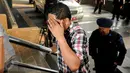 Salah satu tersangka hasil OTT KPK menutup wajahnya saat digiring masuk ke dalam gedung KPK Jakarta, Sabtu (20/6/2015). KPK mengamankan empat orang hasil OTT yang berlangsung pada Jumat (19/6) malam di Palembang. (Liputan6.com/Helmi Fithriansyah)