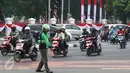 Pengendara Gojek bernama Ari mencari ranjau paku yang berserakan di sekitar Istana Negara, Jakarta, Minggu (14/8). Meskipun tak dibayar, Ari berinisiatif untuk mengumpulkan ranjau paku yang merugikan pengendara tersebut. (Liputan6.com/Immanuel Antonius)