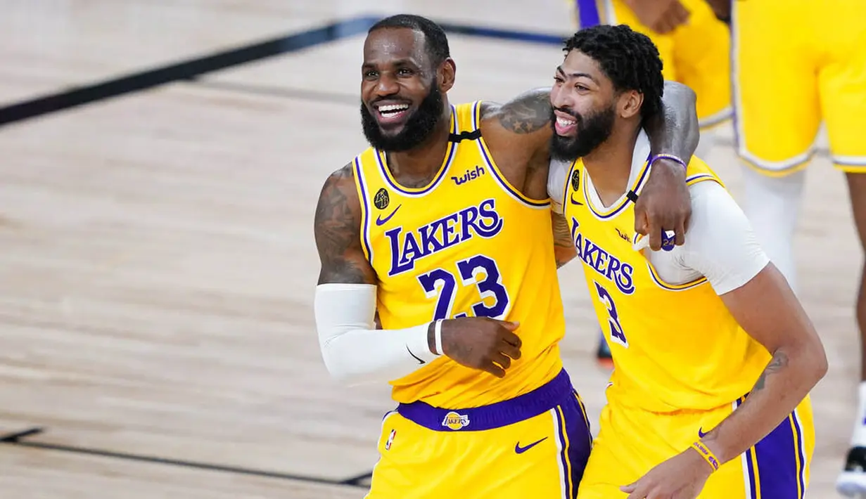 Pebasket Los Angeles Lakers, LeBron James dan Anthony Davis, merayakan kemenangan atas Denver Nuggets pada laga NBA di The Arena, Senin (11/8/2020). LA Lakers menang dengan skor 124-121. (AP Photo/Ashley Landis, Pool)