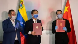 Menteri Luar Negeri Venezuela Jorge Arreaza (kanan) dan Duta Besar China untuk Venezuela Li Baorong (tengah) berfoto bersama dalam upacara penyerahan suplai medis dari China di Caracas, Venezuela (30/3/2020). (Xinhua/Marcos Salgado)