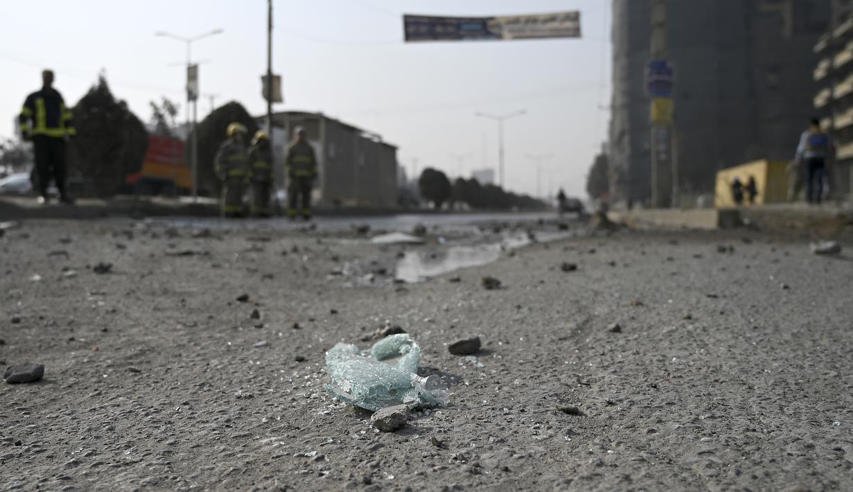 Petugas pemadam kebakaran membersihkan lokasi ledakan bom di Kabul (2/2/2021).  Dua orang tewas ketika ibu kota Afghanistan diguncang serangkaian bom mobil pada jam sibuk, kata para pejabat, sementara seorang polisi kendaraan menjadi sasaran dalam serangan di utara Kabul. (AFP/Bangun Kohsar)