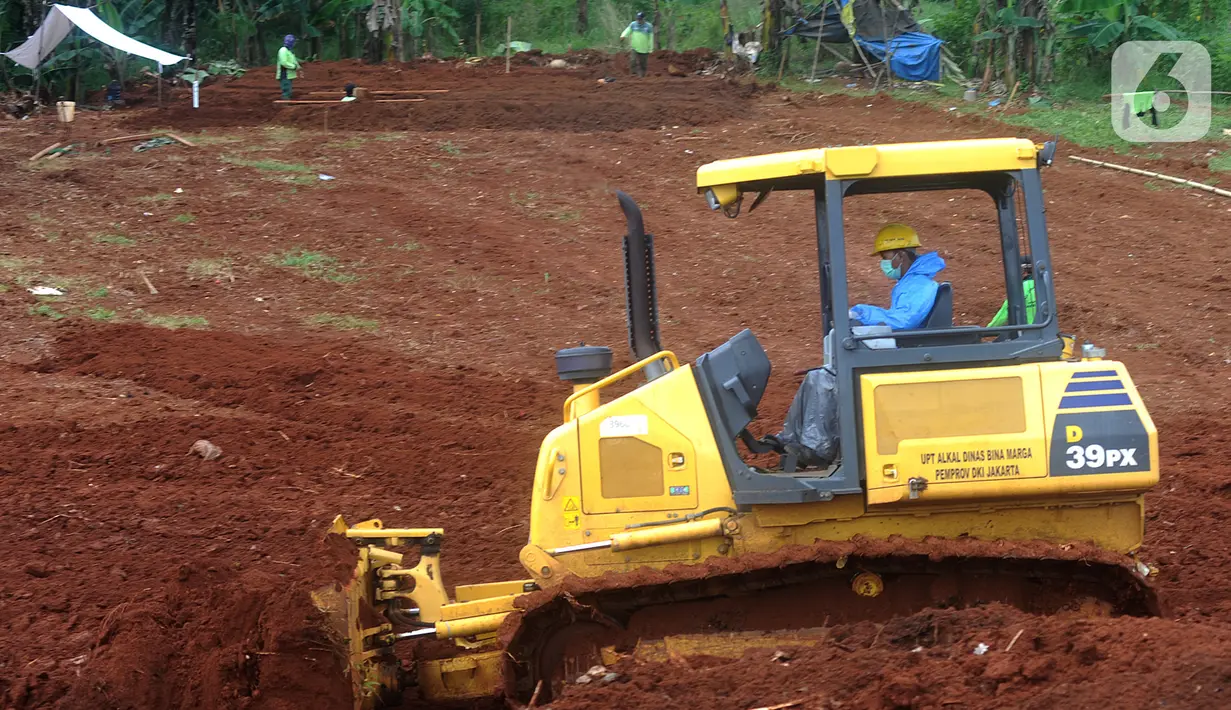 Petugas dengan alat berat meratakan tanah di belakang Blok AA-1 TPU Pondok Ranggon, Jakarta, Kamis (2/4/2020). Dinas Bina Marga Pemprov DKI melakukan pematangan atau perluasan lahan di TPU Pondok Ranggon untuk menangani permasalahan pemakaman korban corona Covid-19. (merdeka.com/Arie Basuki)