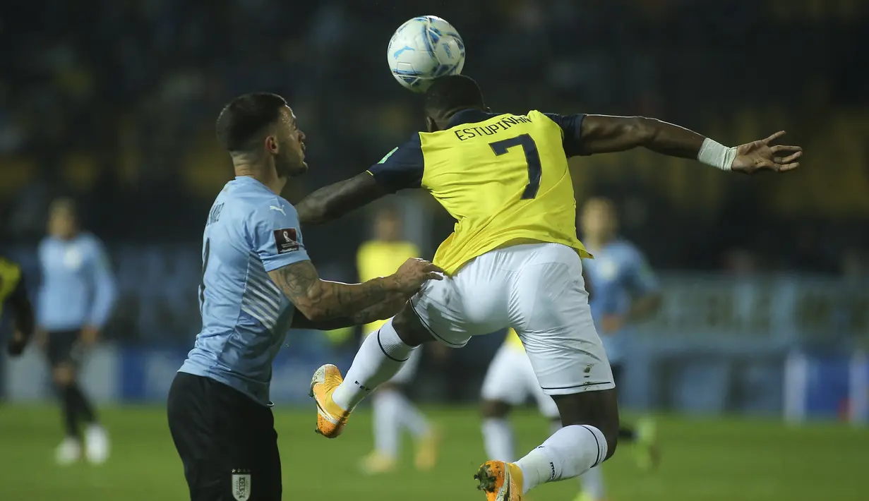 Gelandang Uruguay, Nahitan Nandez dan bek Ekuador, Pervis Estupinan berebut bola pada lanjutan Kualifikasi Piala Dunia 2022 zona Amerika Selatan di Estadio Campeón del Siglo, Jumat (10/9/2021) pagi WIB. Uruguay menang tipis 1-0 lewat gol gasto Pereiro. (Ernesto Ryan / POOL / AFP)