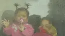 Anak-anak pengungsi melihat keluar dari bus yang berangkat ke Rumania setelah melarikan diri dari perang Ukraina, di persimpangan perbatasan di Palanca, Moldova, pada Jumat (11/3/2022). Invasi Rusia ke Ukraina sudah memasuki hari ke-16 pada hari Jumat ini. (AP Photo/Sergei Grits)