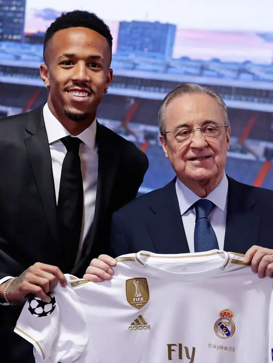 Bek Brasil Eder Militao (kiri) bersama Presiden Real Madrid Florentino Perez berpose dengan jersey klub selama pengenal dirinya di stadion Santiago Bernabeu di Madrid, Spanyol (10/7/2019). Eder Militao diboyong Madrid dari FC Porto dengan transfer 50 juta euro. (AP Photo/Manu Fernandez)