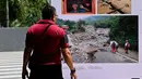 Pengunjung melihat karya pameran foto jurnalistik Prahara Pulau Emas di Museum Tsunami Aceh, Banda Aceh, Aceh, Sabtu, 8 Agustus 2026. (AFP/ Chaideer Mahyuddin)