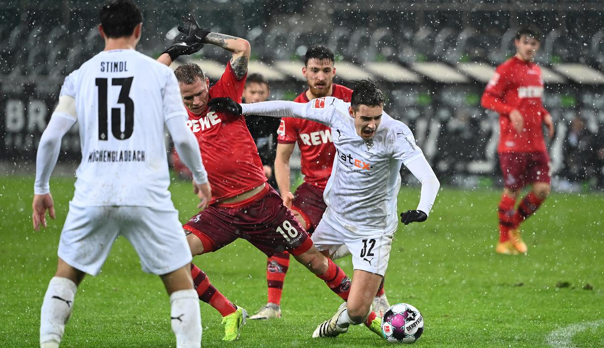 Gelandang FC Koln, Ondrej Duda (tengah) berebut bola dengan gelandang Borussia Moenchengladbach, Florian Neuhaus dalam laga lanjutan Liga Jerman 2020/21 pekan ke-20 di Borussia Park, Sabtu (6/2/2021). FC Koln menang 2-1 atas Borussia Moenchengladbach. (AFP/Ina Fassbender/Pool)