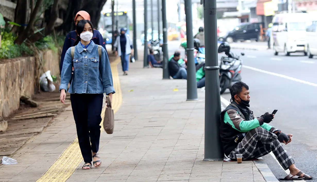 Warga berjalan di trotoar Jalan Blora, Dukuh Atas Jakarta, Kamis (21/1/2021). Untuk mencegah penyebaran virus COVID-19, pemerintah memperpanjang pemberlakuan pembatasan kegiatan masyarakat (PPKM) di Jawa-Bali selama 14 hari kedepan, mulai 26 Januari-8 Februari 2021. (Liputan6.com/Helmi Fithriansyah)