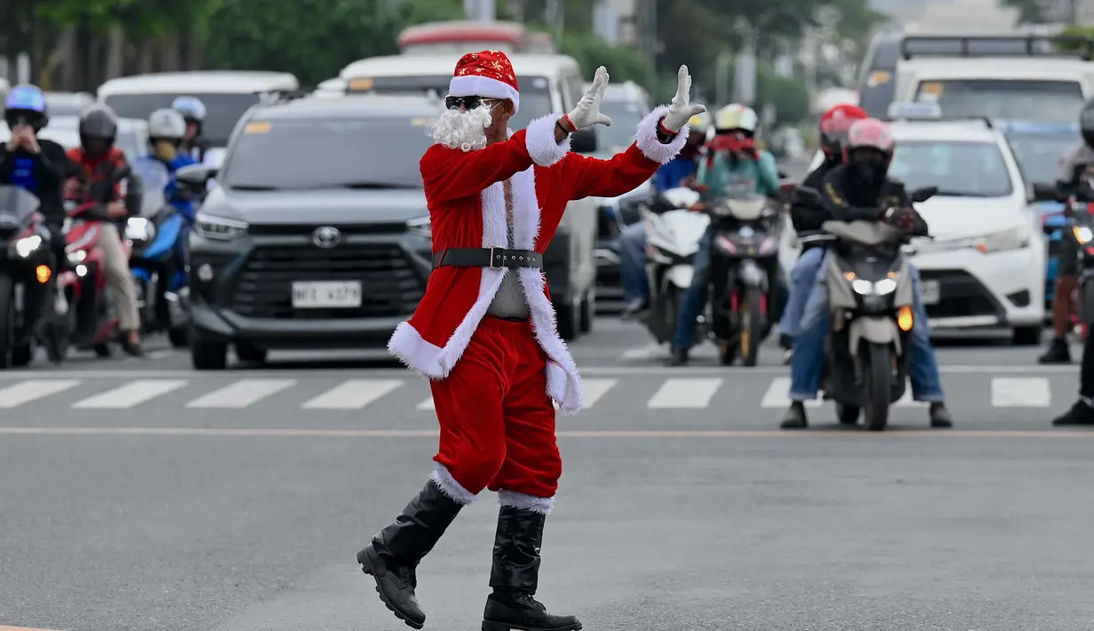 Petugas lalu lintas, Ramiro Hinojas saat mengarahkan kendaraan di sepanjang Macapagal Avenue di Pasay, Metro Manila pada 28 November 2023. (JAM STA ROSA/AFP)