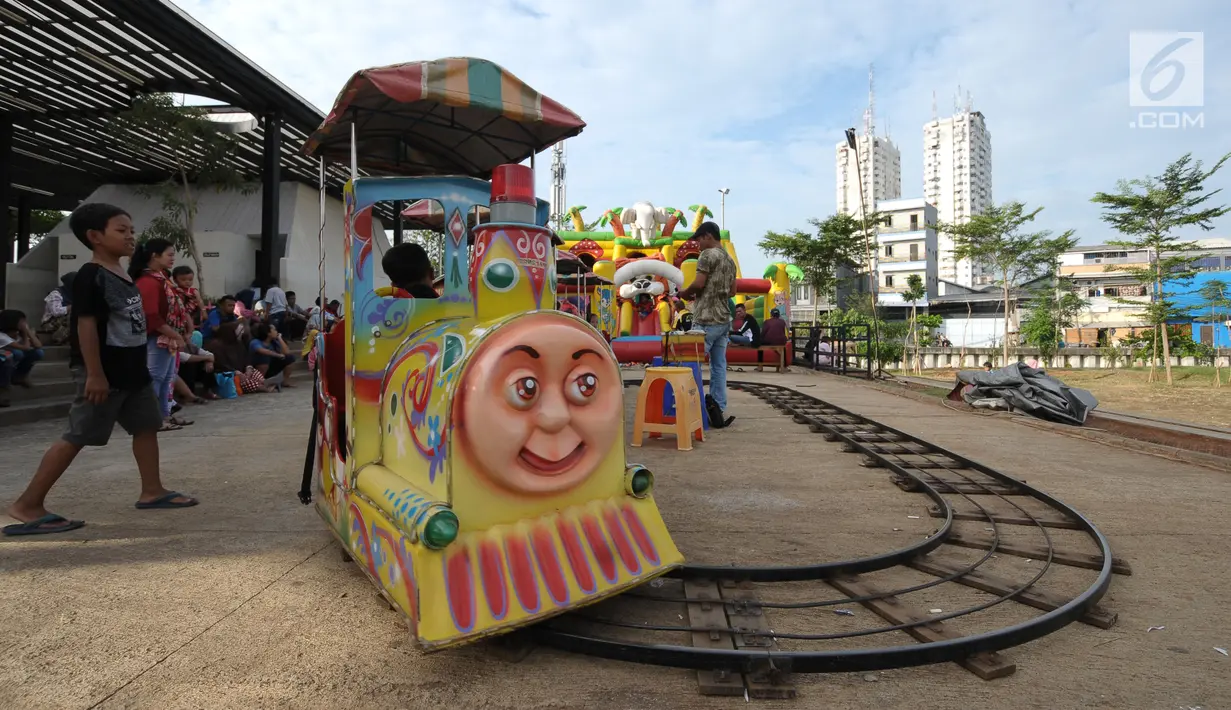 Seorang anak menanti giliran naik kereta di area RTH Kalijodo, Rabu (20/6). Banyaknya pilihan permainan buat anak-anak menjadikan RTH Kalijodo memiliki daya tersendiri untuk menghabiskan waktu libur bersama keluarga. (Lipiutan6.com/Helmi Fithriansyah)
