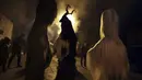 Penari bertopeng melakukan ritual kuno mengusir roh jahat di jalan-jalan Batanovci, Bulgaria, Kamis malam (13/1/2022). Untuk dua tahun ini festival topeng memiliki arti ekstra: orang-orang berharap itu akan membawa kelegaan dari kesengsaraan pandemi corona. (AP/Valentina Petrova)