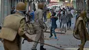 Seorang warga melemparkan batu ke arah polisi saat bentrok di Srinagar, India (11/7). Bentrokan bermula karena adanya kasus pembunuhan terhadap seorang pemberontak muda yang populer di India. (AFP PHOTO/Tauseef MUSTAFA)