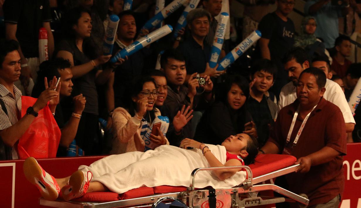 Pemoonton memberi semangat kepada Ratchanok Intanon saat dibawa keluar lapangan setelah mengalami cedera kaki kanan . Kamis (13/8/2015). (Bola.com/Arief Bagus)