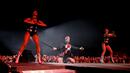 Aksi panggung Robbie Williams bersama para penari di Festival Musik Corona Capital di Meksiko (17/11). Pria 44 tahun ini tampil energik mengenakan setelan jas hitam dan rok yang dihiasi bintang merah. (AP Photo/Eduardo Verdugo)