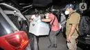Petugas kepolisian membawa boks berisi barang bukti hasil temuan dari penggeledahan eks Kantor DPP FPI, Petamburan, Jakarta, Selasa (27/4/2021). Polisi mengamankan barang bukti seperti bendera tauhid, buku, bahan berbahaya, dan atribut FPI. (merdeka.com/Iqbal S.Nugroho)
