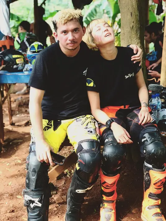 Berbeda dari kebanyakan undangan, pasangan yang memiliki kesamaan hobi main motor itu memajang foto dengan baju penuh lumpur dengan latar belakang ilalang. (Instagram/popsovia)