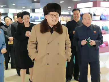 Pemimpin Korea Utara, Kim Jong-un berjalan sambil tersenyum mengunakan jaket dan topi tebal saat mengunjungi pusat perbelanjaan Mirae Shop yang baru dibangun di kompleks Mirae Shop di Korea Utara (28/3). (REUTERS/KCNA)