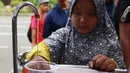 Seorang anak mengambil air minum gratis saat run for water di CFD, Jakarta, Minggu (25/3). Run For Water kolaborasi PAM Jaya, Palyja, dan Aetra mengkampanyekan Hari Air Dunia 2018 mengajak masyarakat ayo peduli air Jakarta. (Liputan6.com/Angga Yuniar)