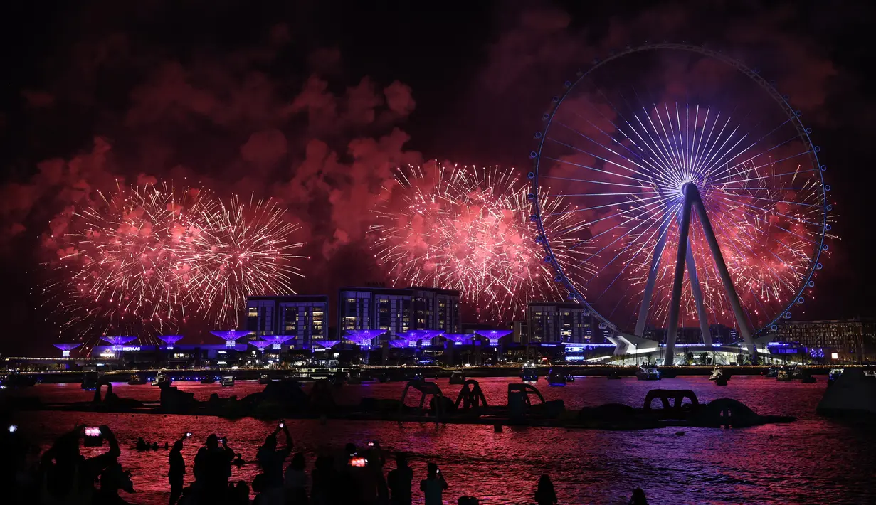 Kembang api menerangi langit pada upacara pembukaan Dubai Eye, yang dikenal sebagai Ain Dubai, di kota Emirat, dekat Dubai Marina, Kamis (21/10/2021). Wahana terbaru ini dibuka untuk menggenjot sektor pariwisata Dubai, setelah dibukanya museum Madame Tussauds pada awal pekan. (Giuseppe CACACE / AFP)