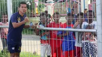 Pemain PS Tira bercengkerama dengan anak-anak di Kota Jayapura seusai sesi latihan, Kamis (5/4/2018). (Bola.com/Permana Kusumadijaya)
