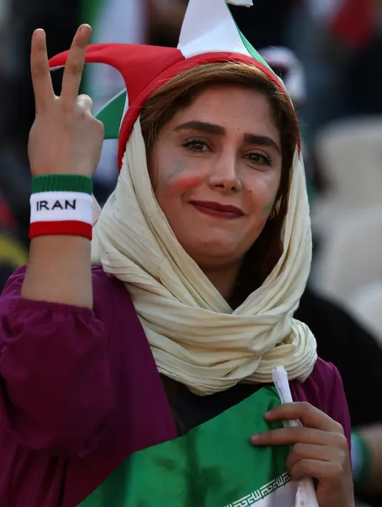 Seorang wanita Iran menunjukkan tanda kemenangan saat menyaksikan laga kualifikasi Piala Dunia 2022 antara Iran dengan Kamboja di Stadion Azadi, Teheran, Iran, Kamis (10/10/2019). Hanya dalam hitungan menit ribuan tiket untuk penonton wanita ludes terjual. (AP Photo/Vahid Salemi)