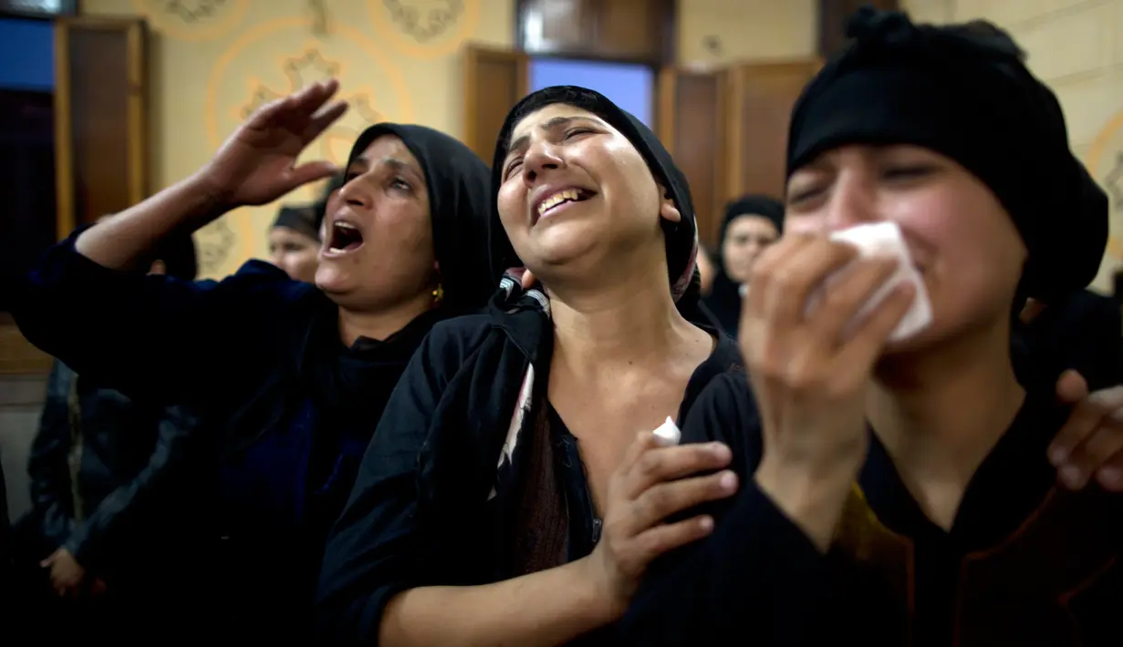 Kerabat orang-orang Kristen Koptik yang tewas menangis saat pemakaman  di Katedral Abu Garnous di Minya, Mesir, (26/5). puluhan orang tewas dan terluka akibat serangan gerilyawan bertopeng di sebuah bus tersebut. (AP Photo/Amr Nabil)