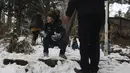 Seorang bocah lelaki bermain salju bersama keluarganya saat menghabiskan akhir pekan mereka di sebuah taman di Teheran utara, Iran, Jumat (25/12/2020). Musim dingin di Iran biasanya dimulai dari bulan Desember hingga Februari.  (AP Photo/Vahid Salemi)