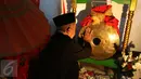 Buang Jayadi (74) melakukan ritual dengan memberi minyak wangi, sekaligus perawatan Gong Si Bolong di rumahnya sekaligus sanggar seni miliknya jelang beberapa hari pementasan pada sebuah acara pernikahan, 9 Januari 2017. (Liputan6.com/Helmi Afandi). 