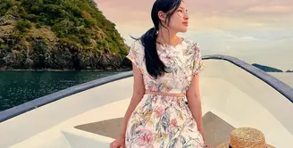 Berlatar langit yang sangat indah, Tiffany berpose di sebuah perahu dengan gaun cantik. Pesonanya semakin memukau dengan dress lengan pendek bermotif floral, disempurnakan dengan rambut panjangnya yang diikat low pony-tail. Foto: Instagram.
