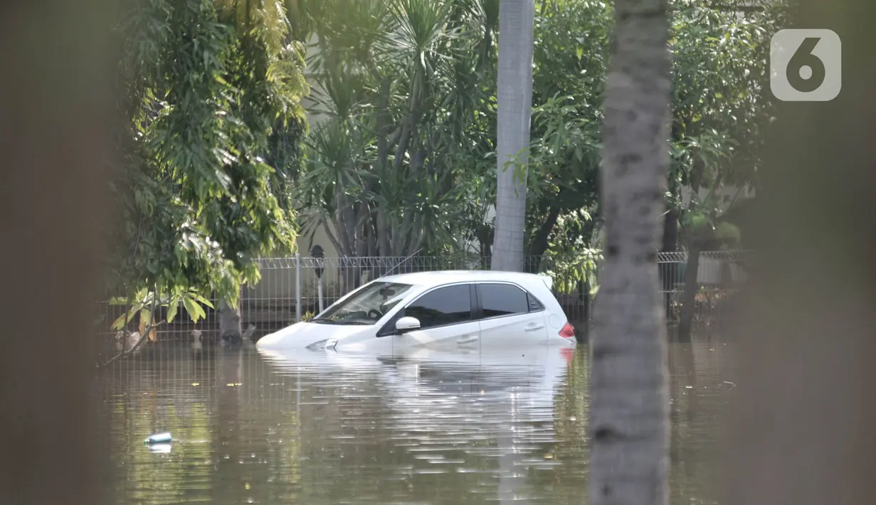 Kondisi sebuah mobil milik warga saat terendam banjir rob di Kompleks Perumahan Pantai Mutiara, Pluit, Jakarta, Minggu (7/6/2020). (merdeka.com/Iqbal S. Nugroho)