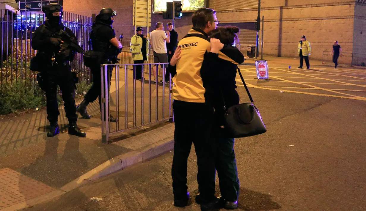 Sejumlah orang bereaksi menyusul ledakan yang terjadi di dalam arena konser penyanyi Ariana Grande di Manchester, Inggris, Senin (22/5). Bintang pop Ariana Grande dilaporkan dalam kondisi baik menyusul ledakan dalam konsernya itu. (Peter Byrne/PA via AP)