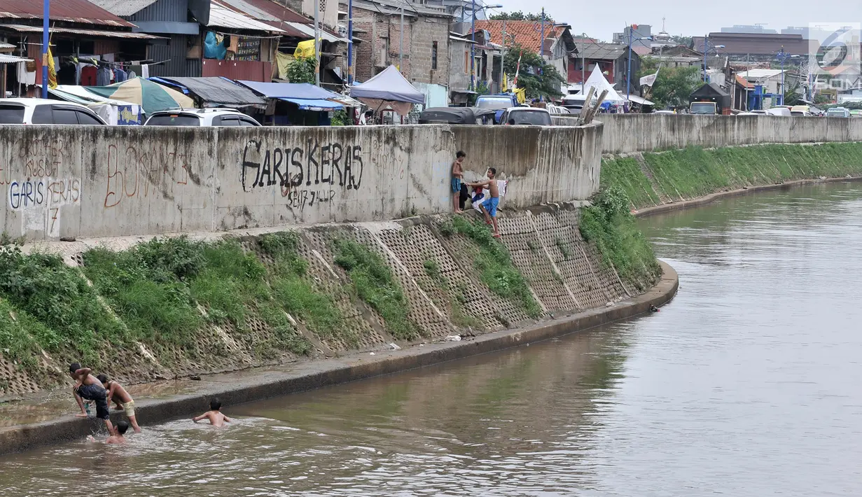 Anak-anak berenang di Kali Ciliwung, Kampung Pulo, Jakarta, Minggu (27/1). Keterbatasan ekonomi menjadikan Kali Ciliwung sebagai tempat pilihan bagi anak-anak setempat untuk menghabiskan waktu bermain saat libur sekolah. (Merdeka.com/Iqbal Nugroho)