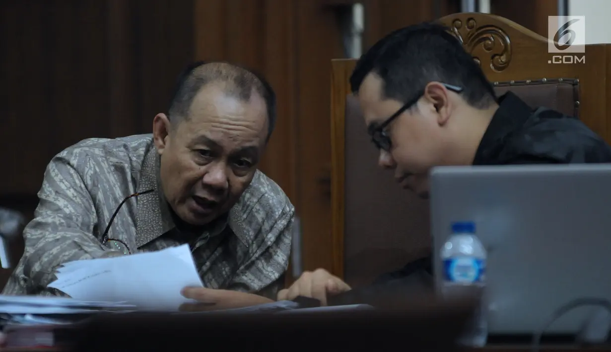 Terdakwa penerbitan SKL terhadap obligor BLBI, Syafruddin Arsyad Temenggung (kiri) berbincang dengan penasehat hukumnya pada sidang lanjutan di Pengadilan Tipikor, Jakarta, Kamis (21/6). Sidang mendengar keterangan saksi. (Liputan6.com/Helmi Fithriansyah)