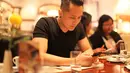 Terlihat asyik dengan telepn genggamnya di hari pertama tiba di Macau, Demian melakukan makan malam di restoran setempat. (Aldivano/Bintang.com)