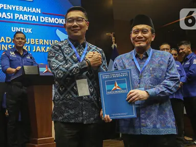 Bakal Calon Gubernur dan Bakal Calon Wakil Gubernur, Ridwan Kamil (tengah) bersama Suswono berpose usai menerima surat rekomendasi Partai Demokrat untuk maju pada Pilkada Provinsi DKI Jakarta di kantor Dewan Pimpinan Pusat (DPP) Partai Demokrat, Jakarta, Selasa (27/8/2024). (Liputan6.com/Angga Yuniar)