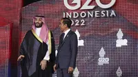 Putra Mahkota Arab Saudi Mohammed bin Salman menyapa Presiden Indonesia Joko Widodo  atau Jokowi yang menyambutnya pada hari pertama Konferensi Tingkat Tinggi (KTT) G20 di Nusa Dua, Bali, Selasa (15/11/2022) pagi.  Selain bersalaman, Jokowi dan para pemimpin itu melakukan sesi foto bersama. (Kevin Lamarque/Pool via AP)