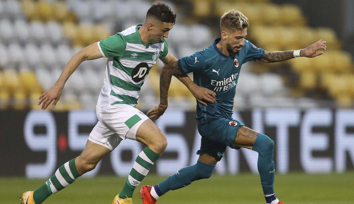 Gelandang AC Milan, Samu Castillejo, berebut bola dengan pemain Shamrock Rovers pada laga babak kualifikasi Luga Europa 2020/2021 di Tallaght Stadium, Jumat (18/9/2020) dini hari WIB. AC Milan menang 2-0 atas Shamrock Rovers. (AP Photo/Peter Morgan)
