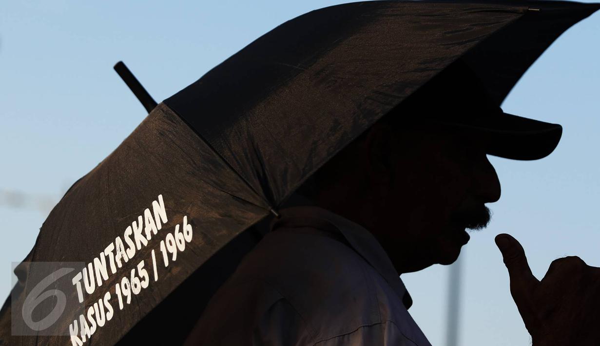 Aktivis JSKK membawa payung yang berisi kritikan saat aksi Kamisan ke-455 di depan Istana Negara, Jakarta (18/8). Aktivis berharap agar pemerintah segera mengambil langkah konkret penyelesaian kasus pelanggaran HAM. (Liputan6.com/Immanuel Antonius)