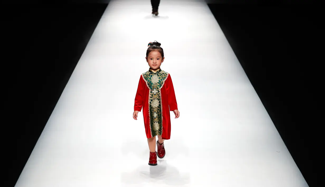 Seorang model anak berjalan di atas catwalk memperagakan karya desainer Amelie Wang pada China Fashion Week di Beijing,  31 Oktober 2017. (AP Photo/Andy Wong)