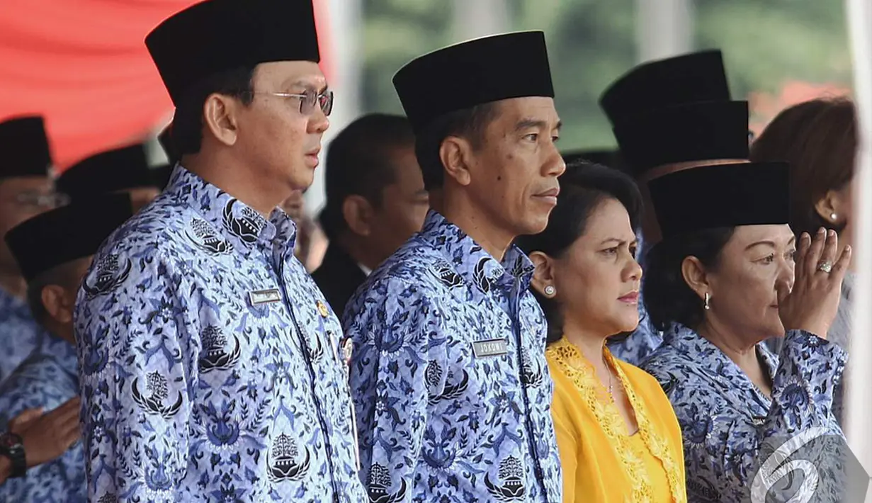 Ahok, Jokowi dan Iriana saat menghadiri Upacara HUT Korps Pegawai Republik Indonesia (Korpri) ke-43 di halaman Monumen Nasional (Monas), Jakarta, Senin (1/12/2014). (Liputan6.com/Faizal Fanani)