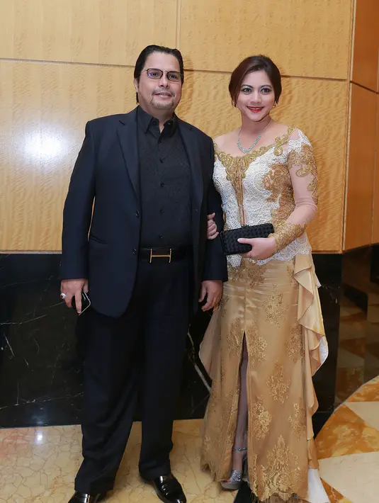 Cut Keke tampil glamor dengan kebaya modern nuansa emas dan suaminya, Malik Bawazier, gagah dengan jas hitam. (Galih W. Satria/Bintang.com)