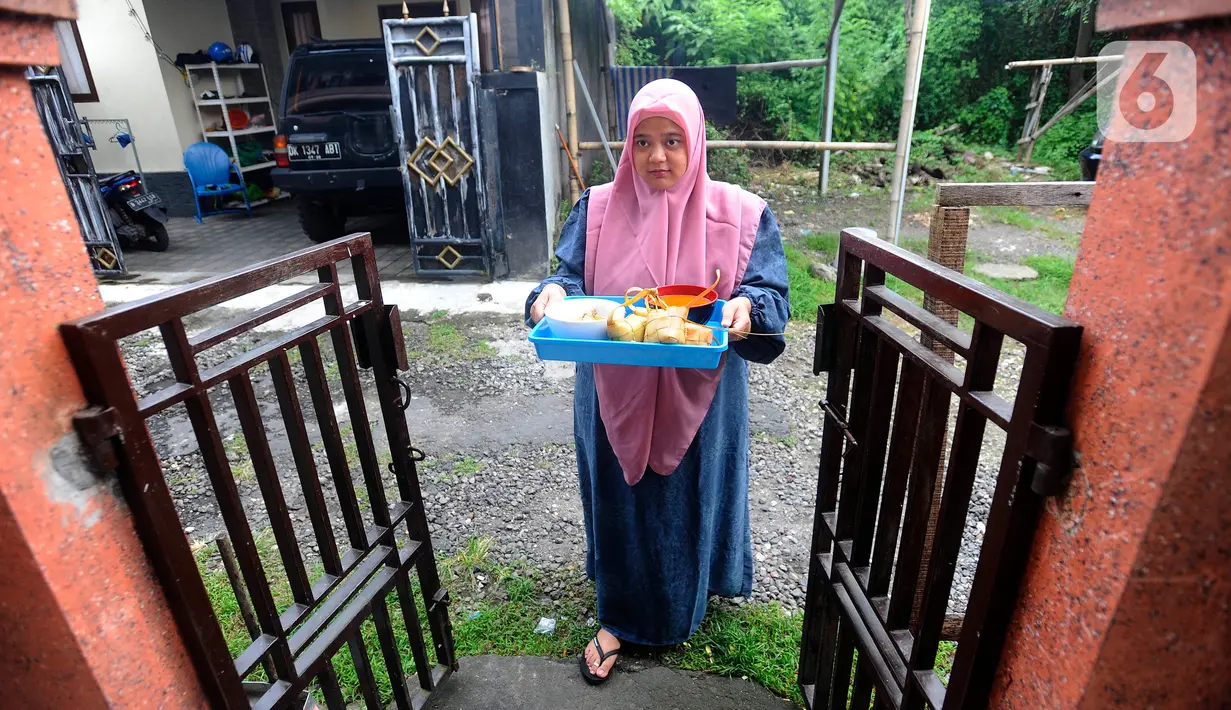 Umat Muslim mengantarkan makanan ketupat di kawasan Perumahan Pondok Kampial Permai, Nusa Dua, Bali, Jumat (21/04/2023). Momen Idul Fitri dimanfaatkan warga untuk saling tolong menolong sebagai semangat toleransi beragama. (merdeka.com/Arie Basuki)