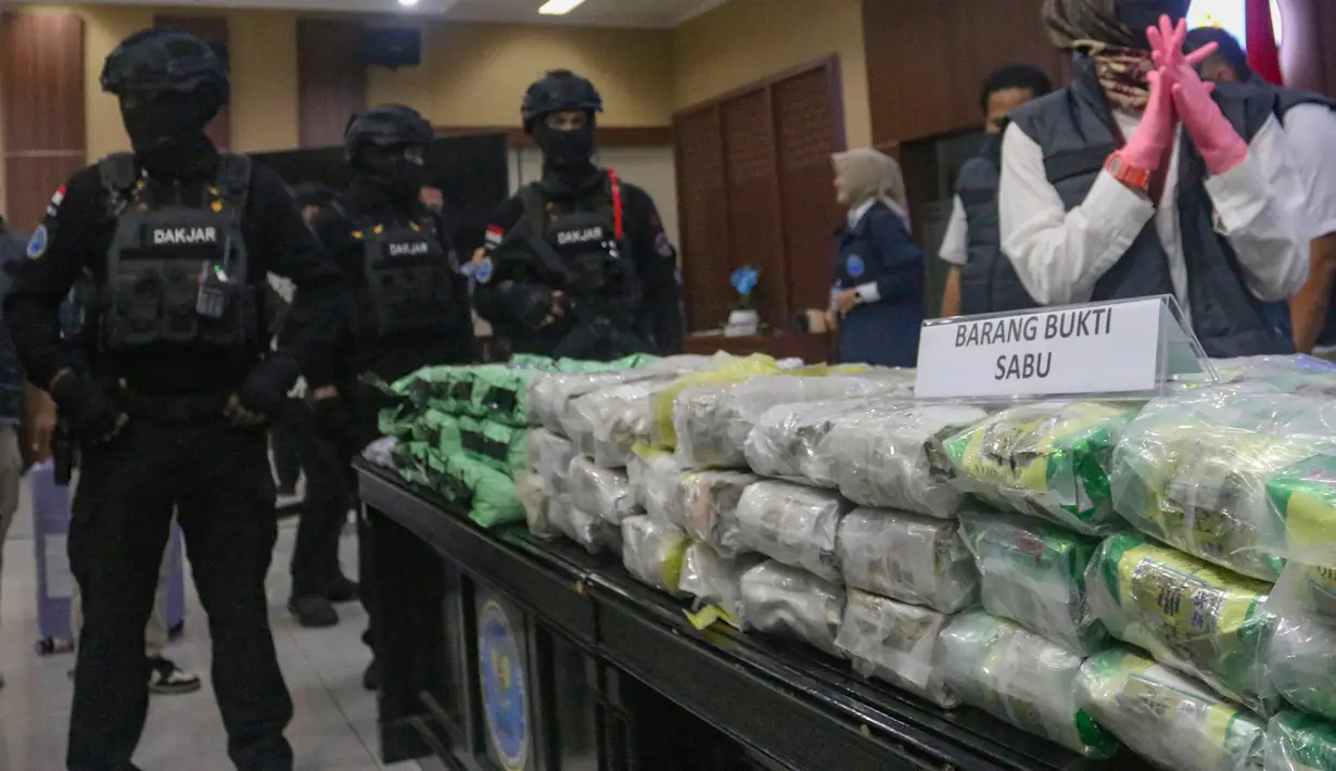 Petugas Badan Narkotika Nasional (BNN) menjaga barang bukti narkotika saat pengungkapan hasil Operasi Saber Bersinar 2026 di Kantor BNN RI, Jakarta, Selasa (19/05/2026). (merdeka.com/Arie Basuki)